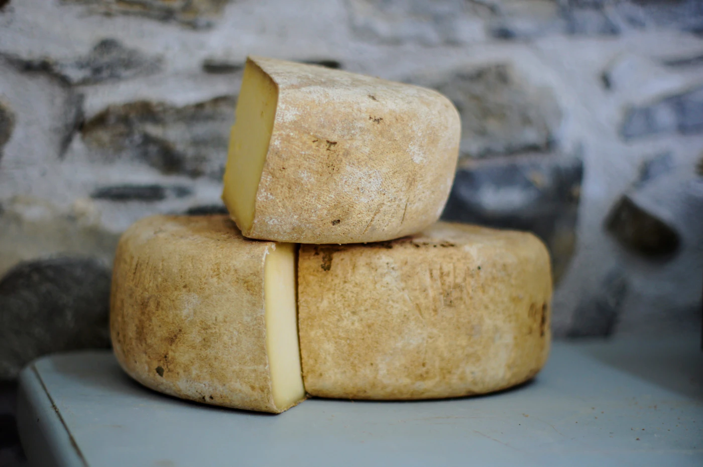 Planche de fromages artisanaux sur une table de bois dans une fromagerie chaleureuse